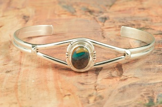 Genuine Royston Turquoise set in Sterling Silver Bracelet. The Royston Turquoise Mine was originally known as the Royal Blue Mine. It produces Turquoise that has a mixture of blues and greens in the same formation. The Royston Turquoise Mine is located in Nye County, Nevada. Created by Navajo Artist Lucy Valencia. Signed L. J. by the artist.